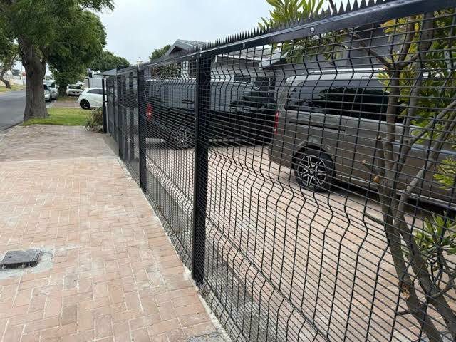 Clear perimeter fence beside a driveway